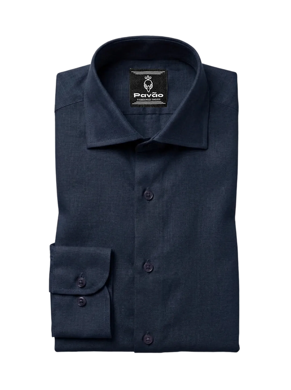 A folded navy blue dress shirt with a spread collar and a single cuff, displayed on a light gray background. The brand label 'Pavão' is visible inside the collar.