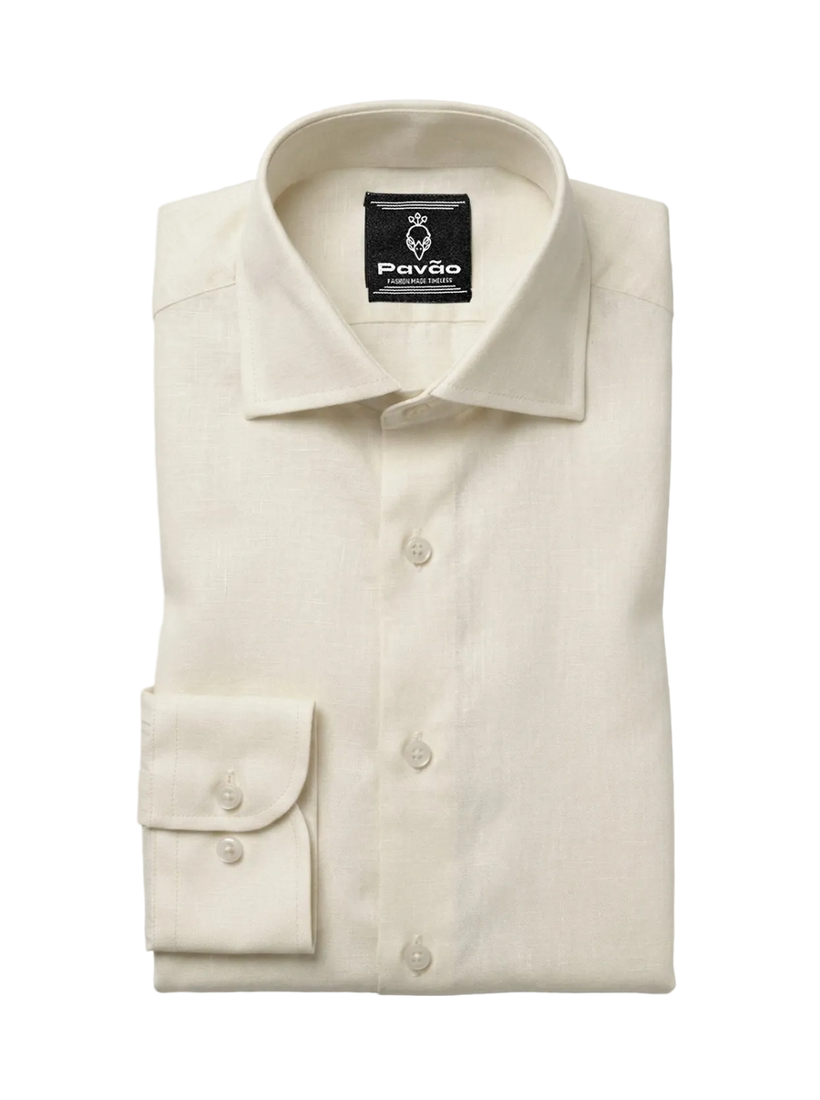A folded cream-colored linen dress shirt by Pavão, featuring a classic collar, button-down front, and a single-button cuff, displayed on a light gray background.