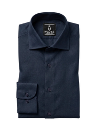 A folded navy blue dress shirt with a spread collar and a single cuff, displayed on a light gray background. The brand label 'Pavão' is visible inside the collar.